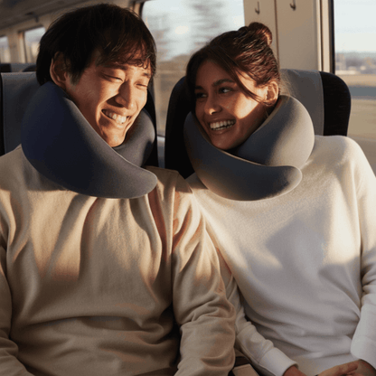Zwei Reisende sitzen im Zug und tragen TravelFit Nackenkissen
